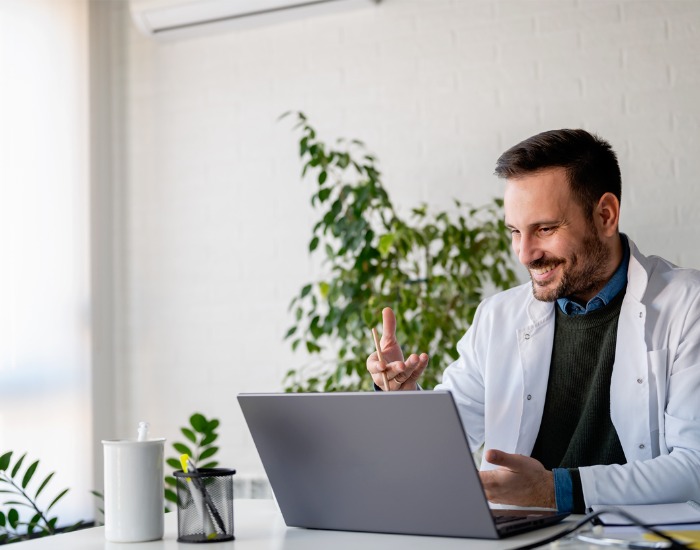 Young dermatologist completing an online dermatology visit from his laptop.